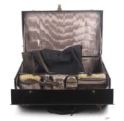 An early 20th century Asprey black leather travelling dressing case and contents.