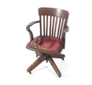 A 20th century oak slat back captain's chair.