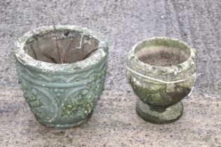 A pair of composite stone garden pots. One on a circular stand.