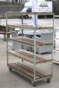 Industrial mobile metal framed shelving unit with wooden slats.