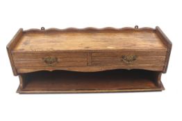 A vintage oak hanging shelf. With a shaped top over two drawers, with an open section below.