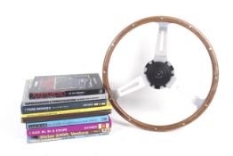 A vintage Jaguar car steering wheel and related books.