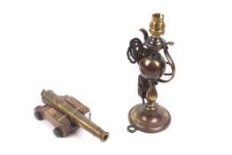 A vintage nautical style oil lamp on gimbal and a model cannon.