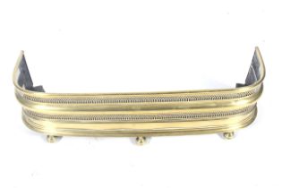 A Victorian brass fire fender.