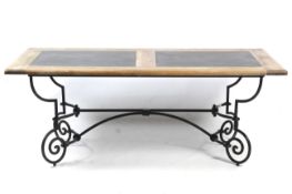 A contemporary dining table. The top inset with slate panels, mounted on a metal base.
