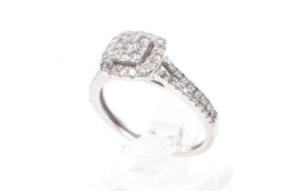 A modern 9ct white gold and diamond halo cluster ring. With diamond two-row split shoulders.
