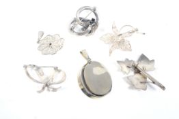 Four silver and white metal brooches and two pendants.