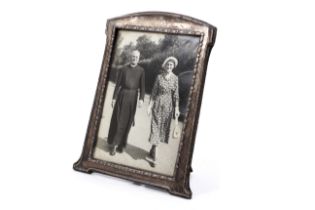 An early 20th century silver mounted shaped-rectangular easel-back photograph frame.