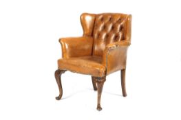 An early 20th century tan leather button back armchair.