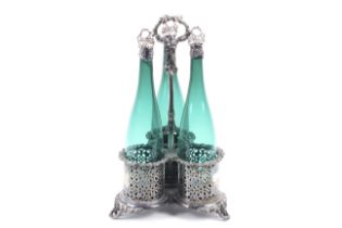 A Victorian silver-plated three bottle tri-form stand and three glass bottles with silver fruiting