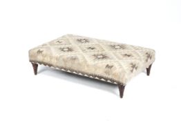 A contemporary woollen upholstered low four legged footstool. H30.5cm x L112.