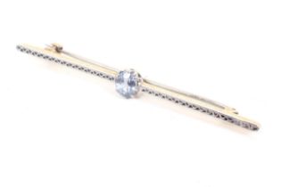 An early 20th century platinum-flashed gold and oval pale-blue sapphire single stone bar brooch