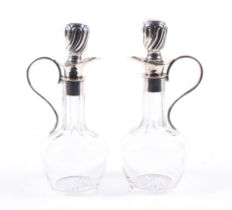 A pair of clear-glass long-neck baluster-shaped oil and vinegar bottles.