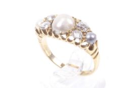 An Edwardian 18ct gold, half-pearl and diamond dress ring. Centred with a 7.