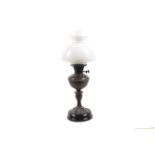 A late 19th/early 20th century oil lamp with white glass shade and clear chimney.