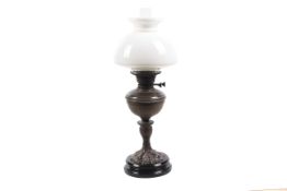 A late 19th/early 20th century oil lamp with white glass shade and clear chimney.