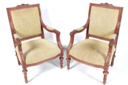 A pair of contemporary rouge and gilt wood open armchairs.