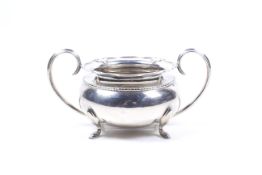 A silver round sugar bowl.