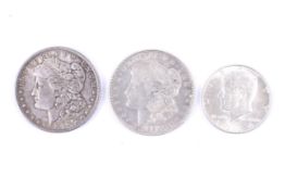 Three USA coins. Comprising two silver dollars, dated 1889 and 1921 and a 1964 half dollar.