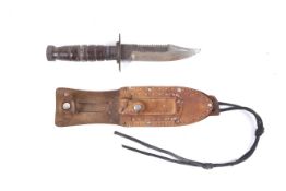 An American Vietnam war military knife and leather sheath with sharpening stone. Knife L23.7cm.