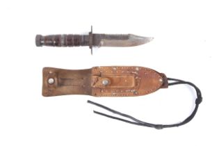 An American Vietnam war military knife and leather sheath with sharpening stone. Knife L23.7cm.