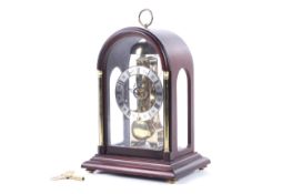 A 20th century Franz Hermle German skeleton mantel clock. With a four glass mahogany case.