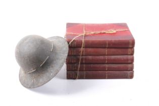 A WWI helmet and five WWI books. The helmet with handwritten engraved name '...