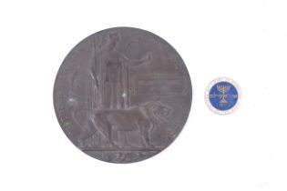 A bronze WWI death plaque and a lapel badge.