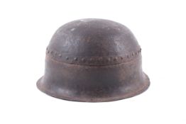 An antique riveted military helmet.