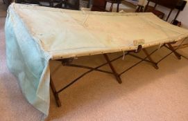 A military campaign bed. Of canvas with wood supports, stamped 'M.R. BONHAM CARTER' to canvas.