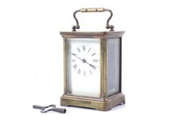 A brass cased carriage time piece. Traditional five bevelled glass form, oval visible escapement.