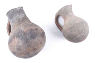 Two unglazed terracotta hand thrown pottery globular jugs.