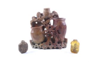 A carved soapstone ornament and two snuff bottles.