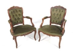 A pair of channel carved wooden open armchairs.