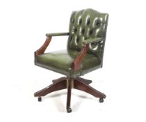 A green leather button back captain's office swivel chair.