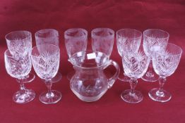 A group of ten assorted vintage crystal glasses and a jug.
