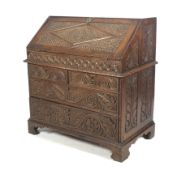 An early 19th century oak bureau with later carving.