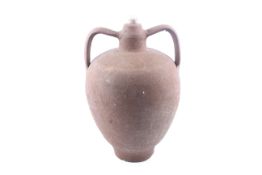 An unglazed terracotta twin handle 'Amphora' storage jar. Wheel thrown body with applied handles.
