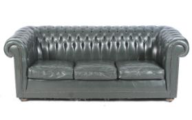 A contemporary dark green leather button back three-seater sofa.