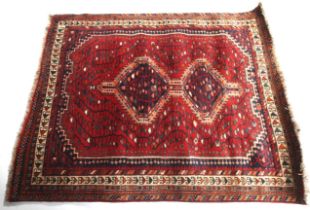 A Persian style red wool rug.