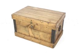 A vintage pine travel trunk. With metal bound corners and drop handles to the ends.