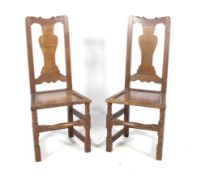 A pair of Arts and Crafts style stained oak hall chairs.
