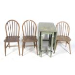 A green painted gateleg dining table and three dining chairs.