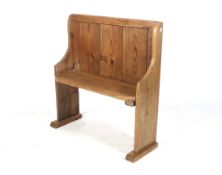 A small rustic antique pine church pew bench. Having a panelled backrest, sloping 'S' shaped ends.