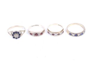 Four 9ct gold and gem set rings. Comprising a three stone garnet ring, size G/H, 1.