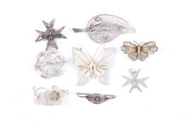 Eight silver and white metal filigree brooches.