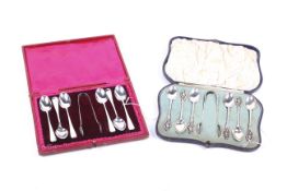 Two sets of six silver tea or coffee spoons and tongs, both in cases.