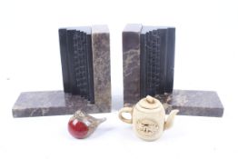 A pair of marble bookends, a bone teapot and a signed paperweight.