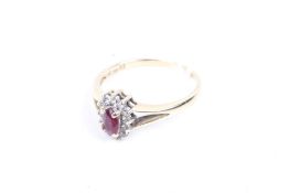 A ruby and diamond oval cluster ring. Stamped '585', size J, 1.