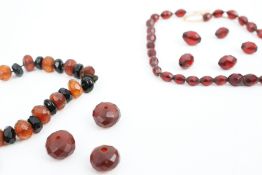Five faceted 'red' amber beads and an imitation-amber necklace.